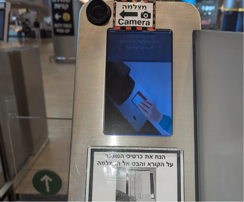 The kiosk camera with a printed sign taped below it